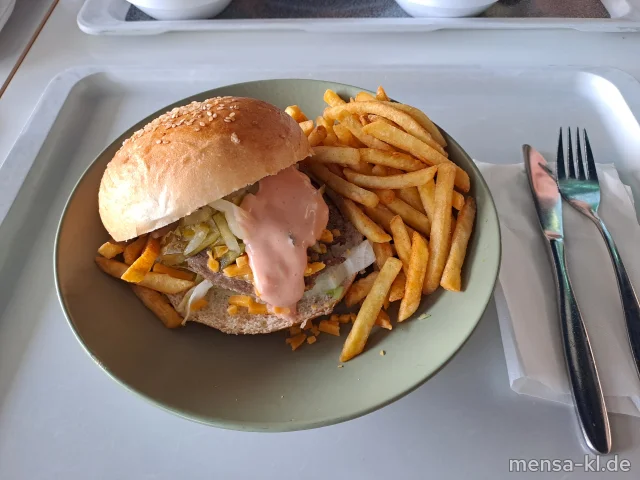 Campus BBQ Burger: BIO-Rindfleisch (Ei,R) belegt mit Cheddar, Tomaten, Eisberg, Gurken (1,5,La,Sw) und Cocktailsoße (1,3,Ei,La,Sl) im Brioche Burger Bun (Gl,La), dazu Pommes frites