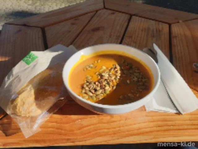 Kürbissuppe mit gerösteten Kürbiskernen und einem Brötchen (Gl)
