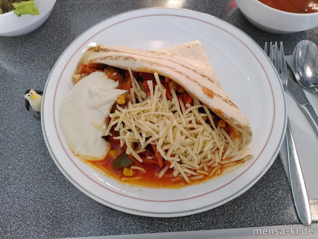 Burrito Tortilla gefüllt mit Bohnen, Paprika, Karotten, Mais und Zucchini (1,2,Gl,Sf), geriebenem veganem Käse (1, Sour Cream-Dip (Gl,Nu,Sf) und Salat