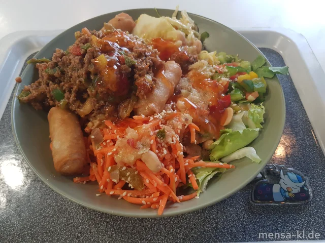 Bowl mit Tomaten, Karotten, Paprika, Krautsalat (Gl,Sf,Se,So), Asia-Nudelpfanne mit Frühlingsröllchen (En,Gl,So), dazu Ananas-Chili-Dressing (1,5,Gl,Nu,Sw,Sf,So)