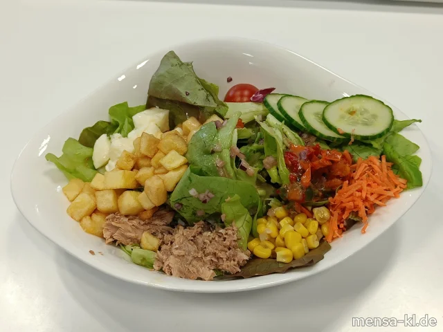 Gemischter Salatteller mit Cherrytomaten, Salatgurken, Paprika, Thunfisch (3,Fi,So) frittierte Kartoffelwürfel und gebackenem Halloumi (La), dazu ein Honig-Balsamico-Dressing (1,5,Sw)