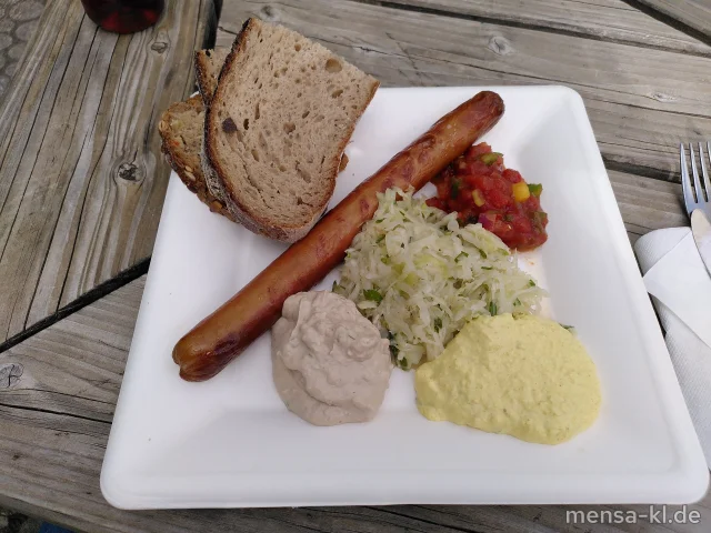 Vegane Rostbratwurst von RAGING PIG oder Lange Rote Bratwurst von der Metzgerei Heiko Brath (2,3,8,R,S) oder grobe BIO-Bratwurst vom Bärenbrunnerhof (Ei,Sf,R,S), wahlweise folgende hausgemachte Dips, Salsa-Dip (Sl), Mango-Curry-Dip (La,Sf), Feta-Balsamico-Dip (1,5,La,Sw,Sf), dazu Krautsalat (1,5,Sw)
