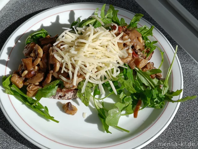 "Pilzstulle": Große Scheibe Sauerteigbrot mit Champignons, Gruyére, Rucola, getrocknete Tomaten und Pinienkerne (Gl,La) und Karottensalat
