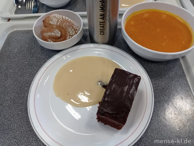 Kartoffel-Kürbis-Suppe (Gl), dazu ein Roggenbrötchen (Gl) und ein Stück veganer Schoko-Brownie (Gl) mit Mandel-Vanillesoße (Nu)