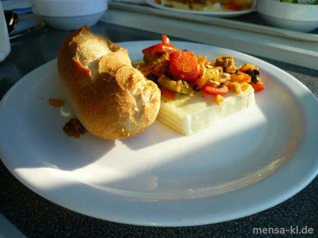 Schafskäse überbacken mit Paprika, Oliven und Peperoni und Zwiebeln (3,6,La,V), dazu ein Baguettebrötchen (Gl,V) und Salat