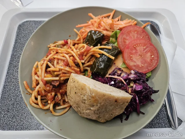 Vegane Bowl mit Tomaten, Gurken, Paprika, Rotkohl (5,Sw), griechische Spaghetti (Gl,So), gefüllte Weinblätter, dazu Minigugelhupf oder Foccacia (Gl) und Balsamico-Dressing (5,Sw)