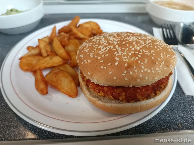 Crispy-Chicken-Burger (1,Gl,Ei,La,Se,So,G) mit Koriander-Ingwer-Dip im Burgerbrötchen (Gl,Se), dazu Potato-Wedges und Salat