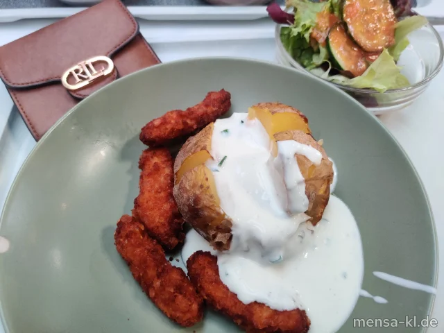 Baked Potatoes mit Cheddar überbacken (1,La), dazu Hähnchen-Chili-Sticks (1,Gl,La,G), Sour Cream (La) und Blattsalat