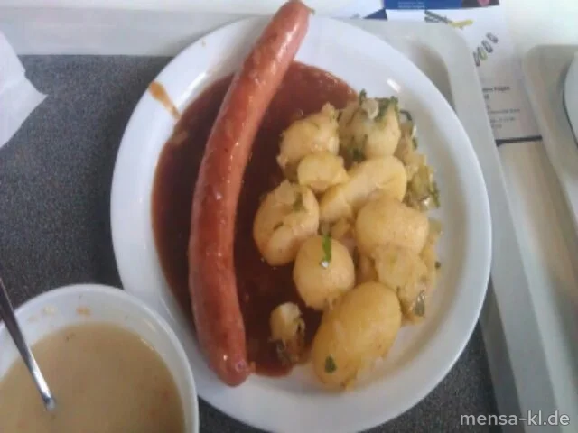 Gebratene Käsekrainer Hauswurst (1,3,8,S), dazu Hüttenkartoffeln (S), Zwiebel-Specksoße (2,S,A) und Salat