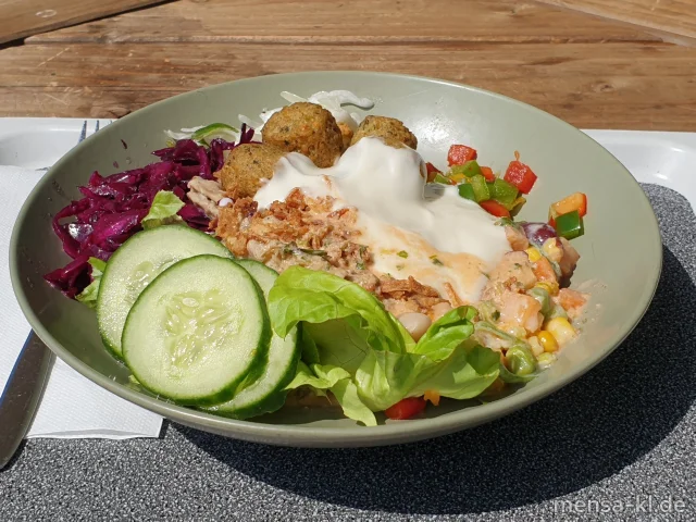 Bowl mit Karotten, Kraut, Gurken, Tomaten, Paprika, Proteinsalat mit Mais, Bohnen, Kichererbsen und Kidneybohnen (1,5,Gl,Nu,Sw), dazu Gemüsekroketten (Gl,Sl), Röstzwiebeln (Gl) und Basilikum-Dressing (5,Sw,Sf)