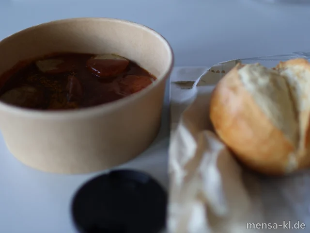 Kalbsbratwurst (8,K) mit Currysoße (1,5,La,Sw,Sl,Sf), dazu ein Kaiserbrötchen (Gl)