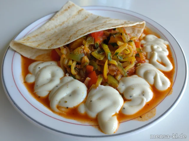 "Fajita Pueblo" mit Paprika, Zucchini und Zwiebeln in mexikanischer Soße, dazu veganer Sour Cream-Dip (1,9,Gl,Ei,La,Sf), Tortillas (2,Gl) und Salat (1,5,Sw,Sf)