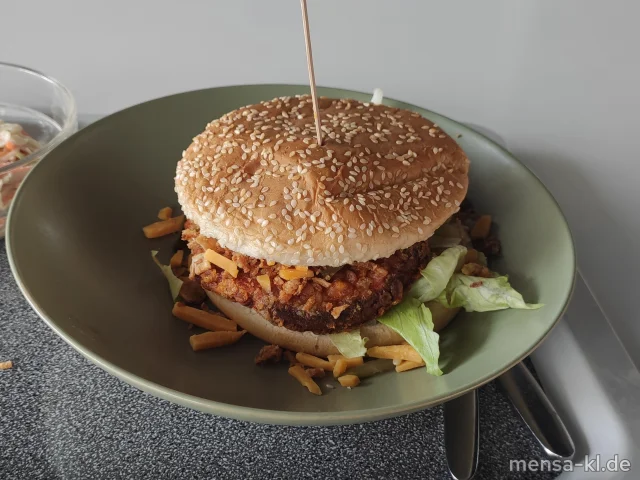 Campus Chicken Burger: Crispy Chicken (Gl,Sl,G) belegt mit Cheddar, Eisberg, Röstzwiebeln und Gewürzgurken (1,9,Gl,La) im Burger Bun (Gl,La), dazu Coleslaw