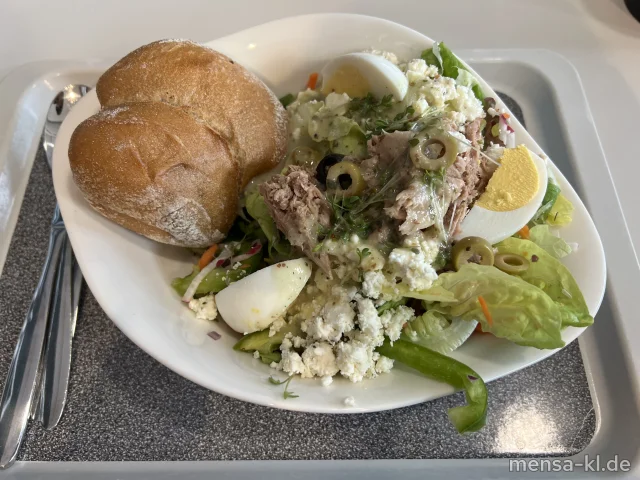 Nizza-Salat mit Oliven, Eiern, Thunfisch, Paprika, Zwiebeln und Schafskäse (3,Fi,Ei,La,So), dazu ein rustikales Körnerbrötchen (Gl,Se,So)