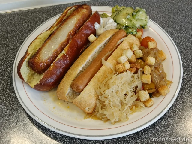 Kikok Hähnchen Bratwurst (3,8,G), Kikok Hähnchen Wiener (2,3,8,G), Thüringer Bratwurst (8,S), vegane Bratwurst (Gl), Brezel Brioche Hot-Dog-Brötchen (Gl,Ei,La), verschiedene Hot-Dog-Brötchen (Gl), Topping-Station (1,5,Sw,Sf), kleine Ofenkartoffel, Maiskolben und Salate