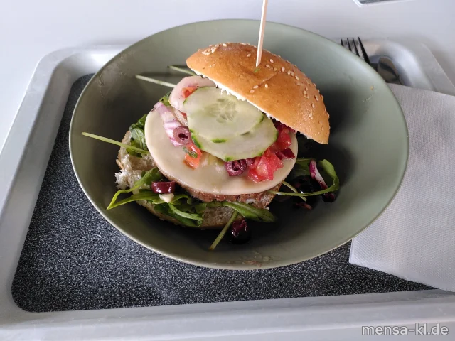 Italien Campus Burger: BIO-Rindfleisch (Ei,R) belegt mit getrockneten Tomaten, Fleischtomaten, Mozzarella, Rucola, schwarze Oliven, Salatgurken (1,9,Sl,Sf) und Kräuterfrischkäse (1,Gl,La,Sf) im Brioche Burger Bun (Gl,La)