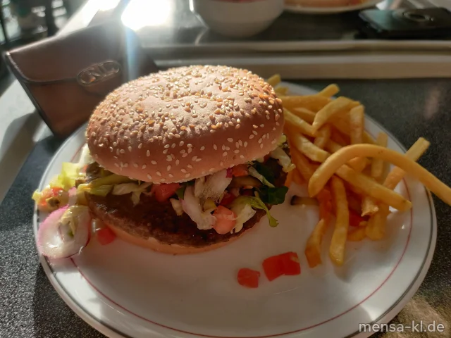 Rinderburger belegt mit Eisberg, Tomaten, Zwiebeln und Gurken im Burgerbrötchen (5,Gl,Sw,Sl,Sf,Se,R), dazu Pommes frites und ein Beilagensalat nach Wahl